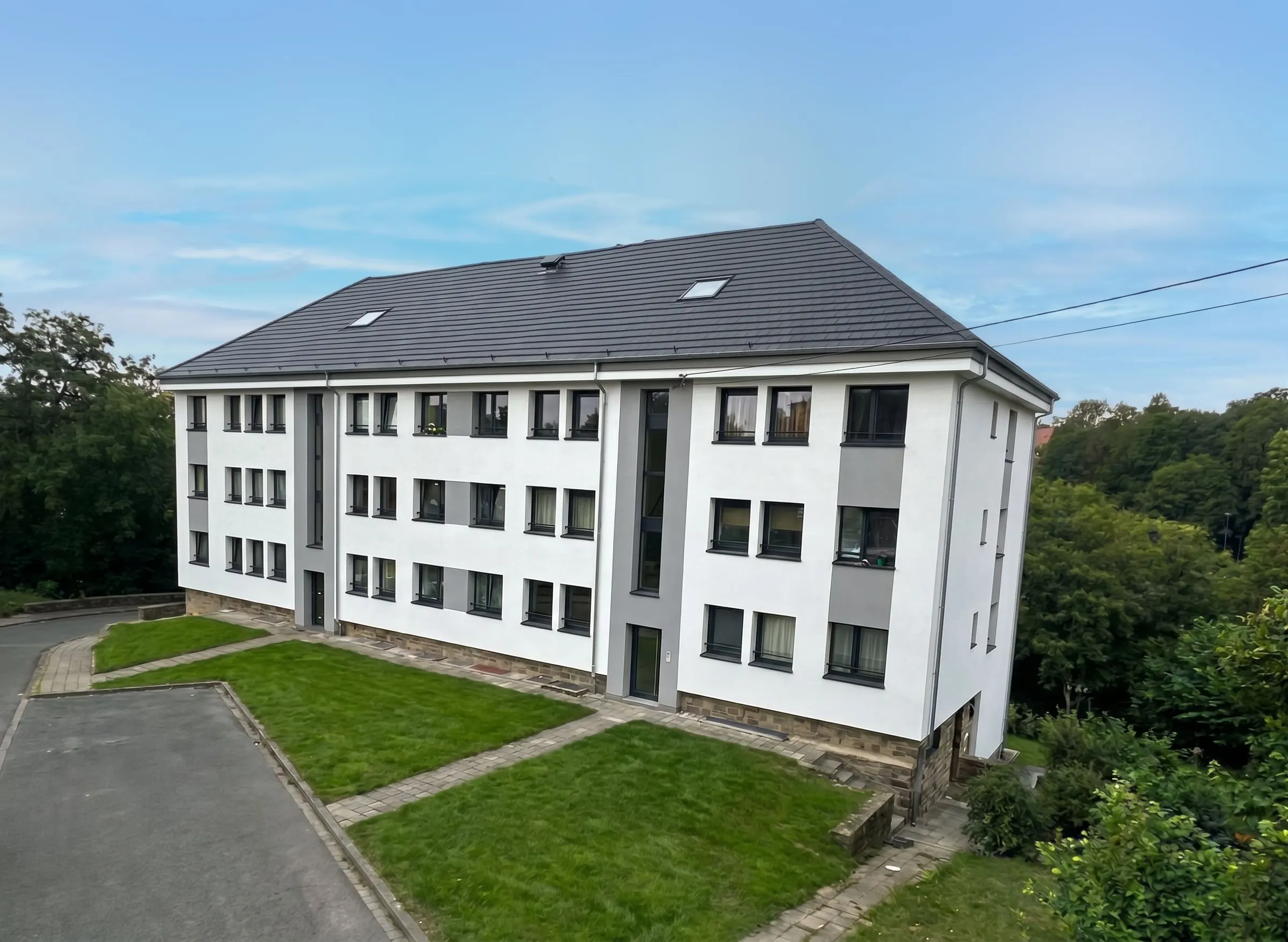 Immeuble de trois étages à Namur, façade blanche et grise terminée, vu d’en haut